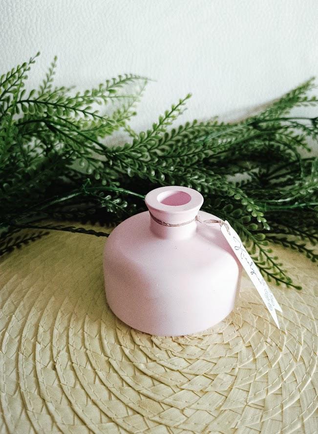 Petit vase diffuseur de parfum rose pâle.