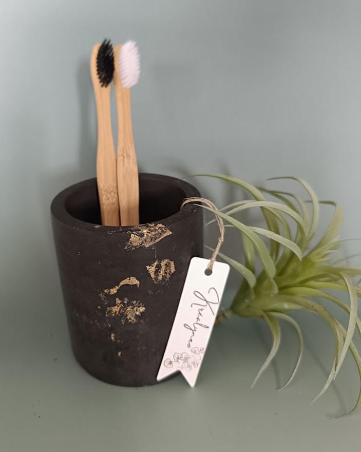 Pot rangement brosses à dents noir et or.