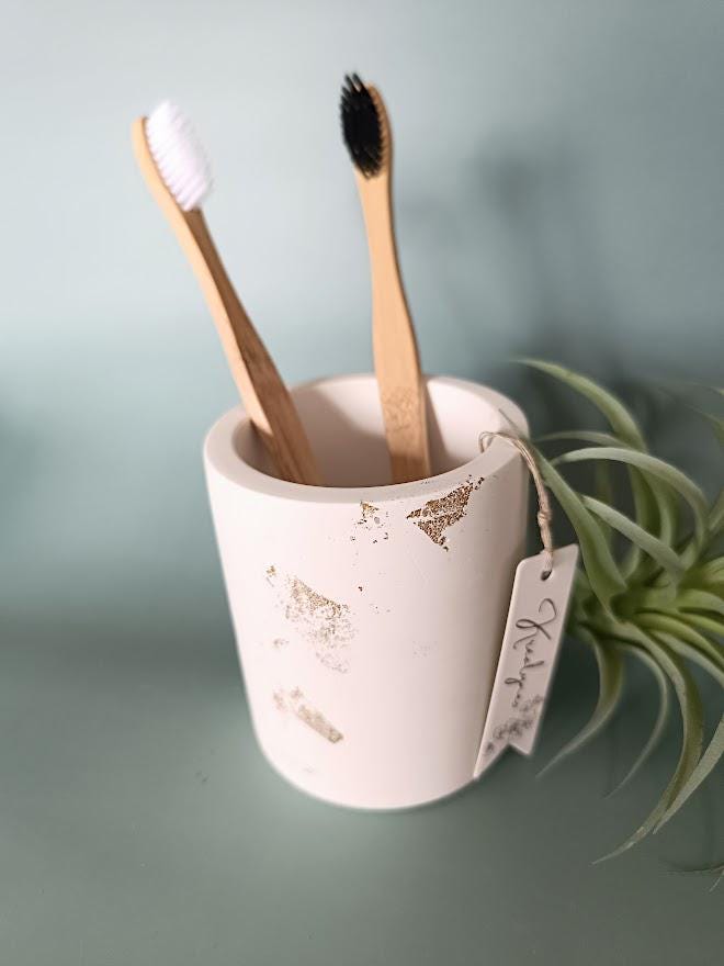 Pot rangement brosses à dents blanc et or.