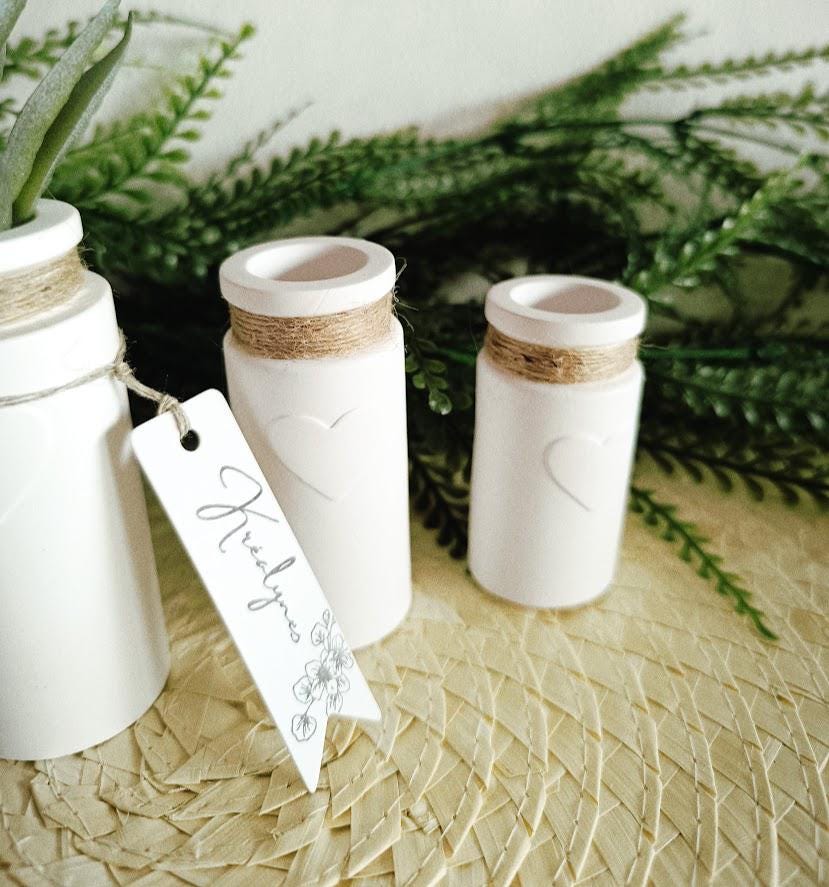 Trois petits vases décoratifs blancs.