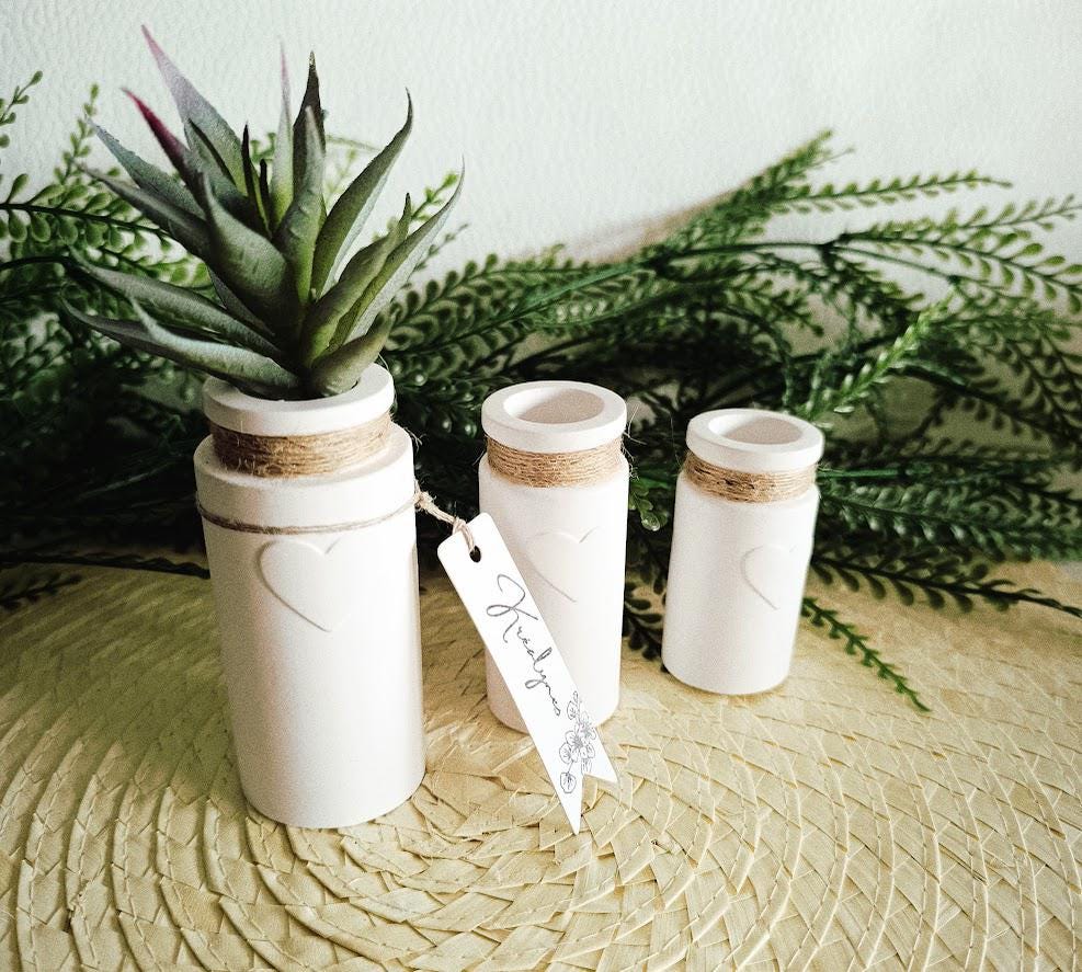 Trois petits vases décoratifs blancs.