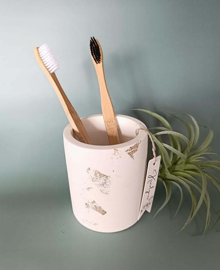 Pot rangement brosses à dents blanc et or.