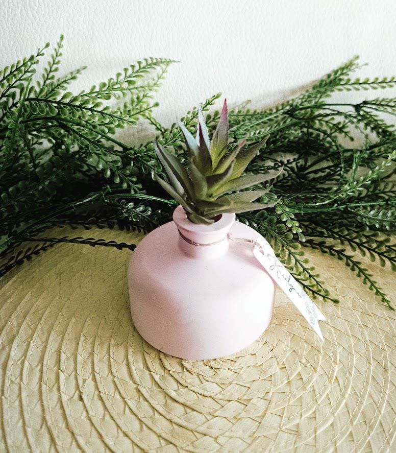 Petit vase diffuseur de parfum rose pâle.