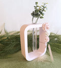 Vase de forme rectangulaire rose et blanc.